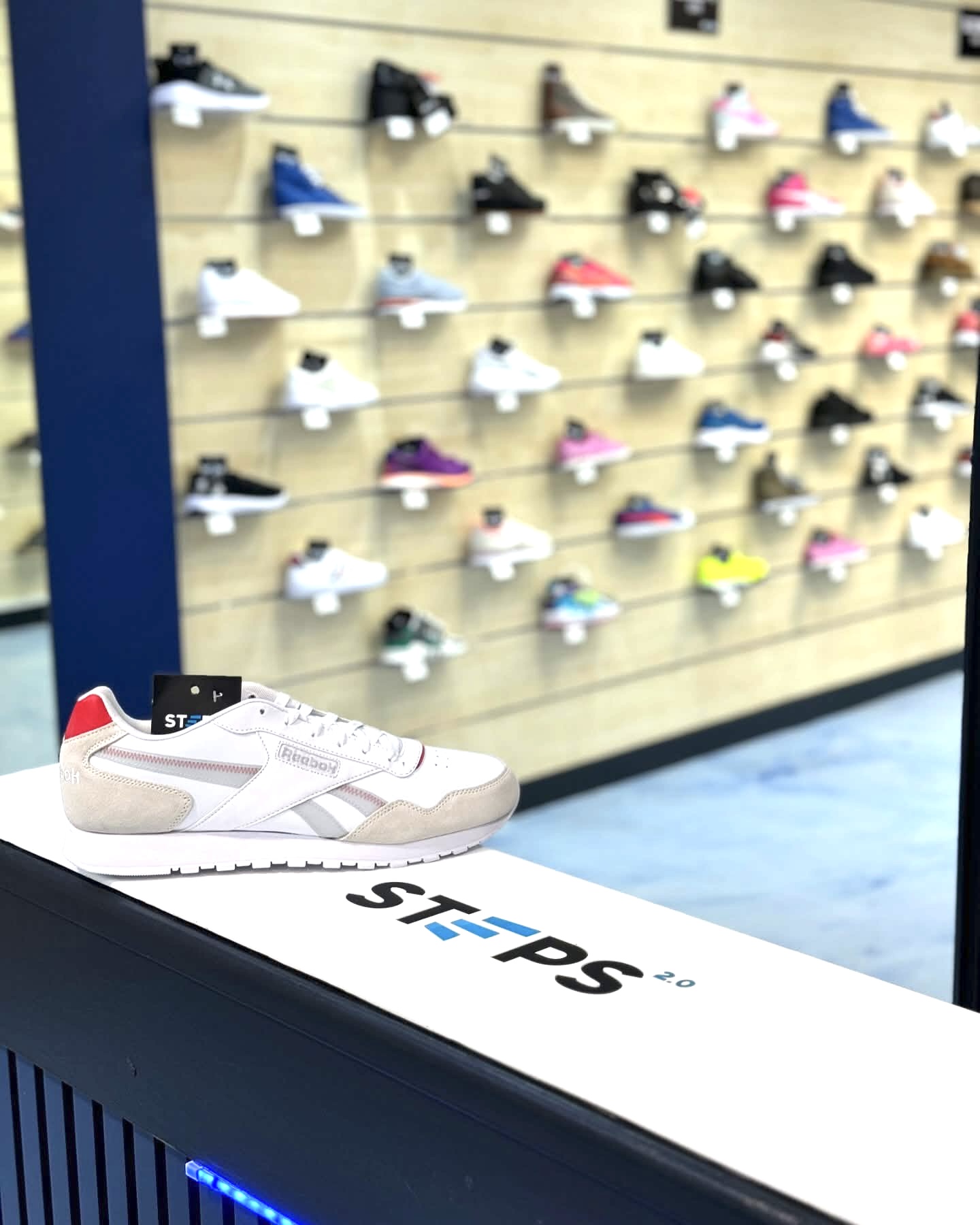 Interior — a Reebok trainer on a Steps 2.0 plinth, slatwall behind