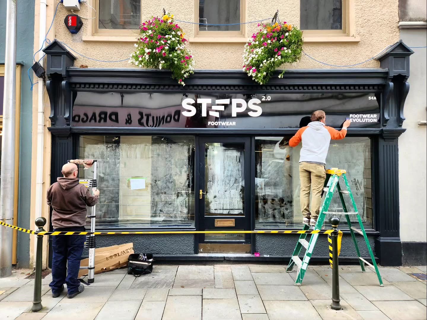 Install in progress — two installers working on the shopfront fascia